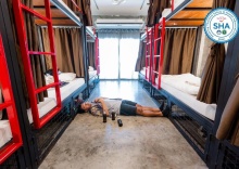 Кровать в общем номере с балконом и с красивым видом из окна в Sleeper Hostel