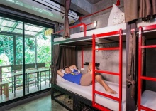 Кровать в общем номере с балконом и с красивым видом из окна в Sleeper Hostel