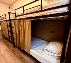 Кровать в мужском шестиместном номере в Берег